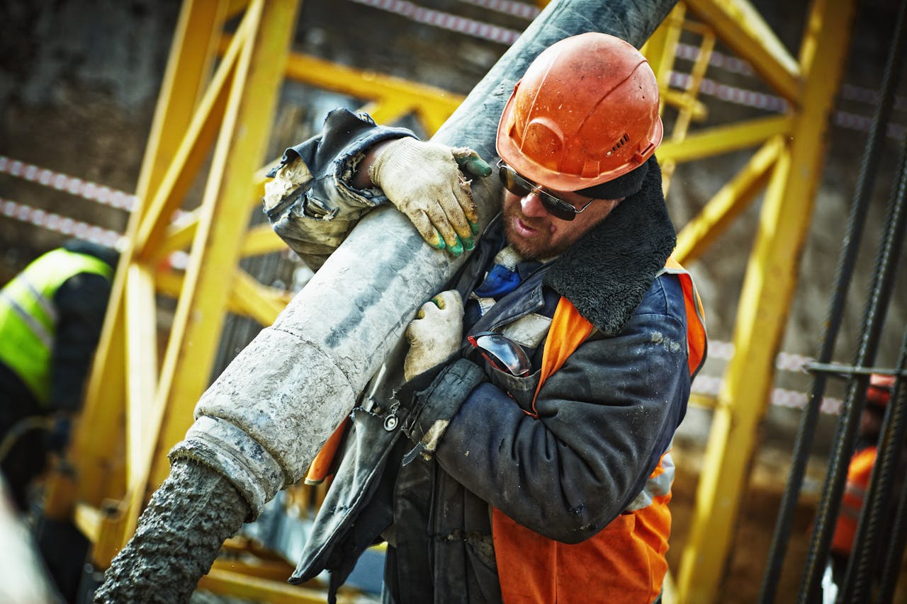 services-04 Construction worker in safety gear handling equipment on an active site.